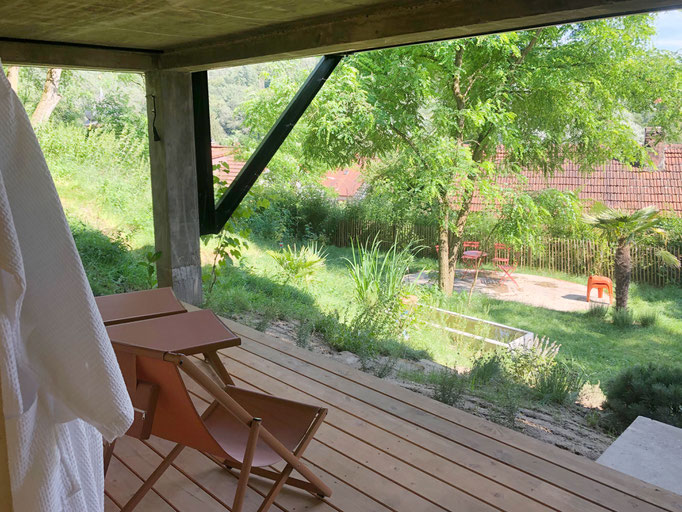 Ruheterrasse neben der Sauna. Im Sommer schattig, im Winter sonnig. Betonbadewanne mit selbstgesammeltem Regenwasser und Kaltdusche.