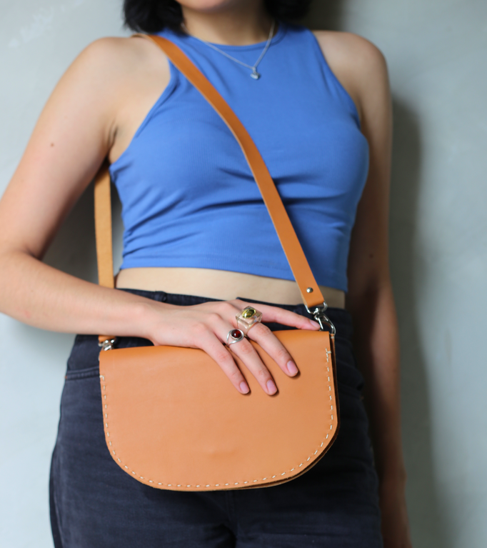 bolso de piel diseñado y confeccionado por CONDESSA LERATHER MR, bolso de piel genuina de forma de media luna, ideal para colgar cruzado al cuerpo o en el hombro, en color miel o camel, ideal para salir a caminar y dejar las manos libres.