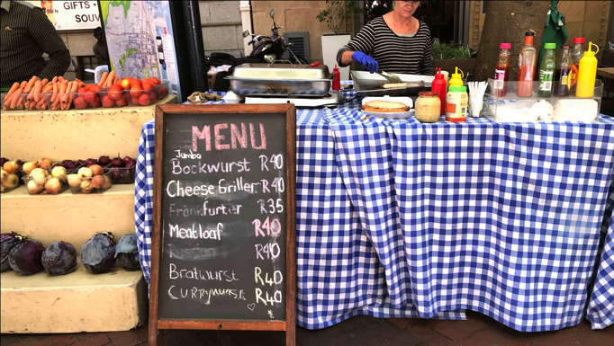 2020 | Kapstadt | Foreshore, George Mall, «Earth Fair Market»: Ohne Curry-, Bock- und Bratwurst funktioniert «Küche» offensichtlich auf der ganzen Welt nicht.
