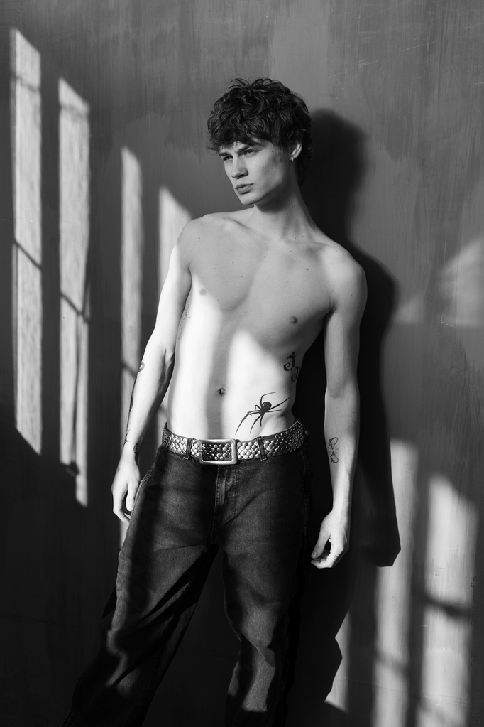 Joshua gefotografeerd in Studio 54, dit is een daglichtstudio. Mooie lichtinval door de ramen met schaduw. Hij draagt een jeans, zonder shirt en zijn tattoo's zijn zichtbaar. Stefan van Ruijven Fotografie heb de fotoshoot dag georganiseerd
