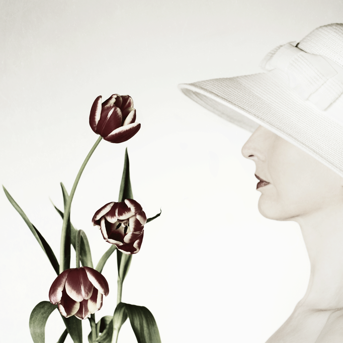 Manuela Deigert Bildsprache Poetisches halbes Selbstportrait im Profil mit weissem Hut und drei roten Tulpen