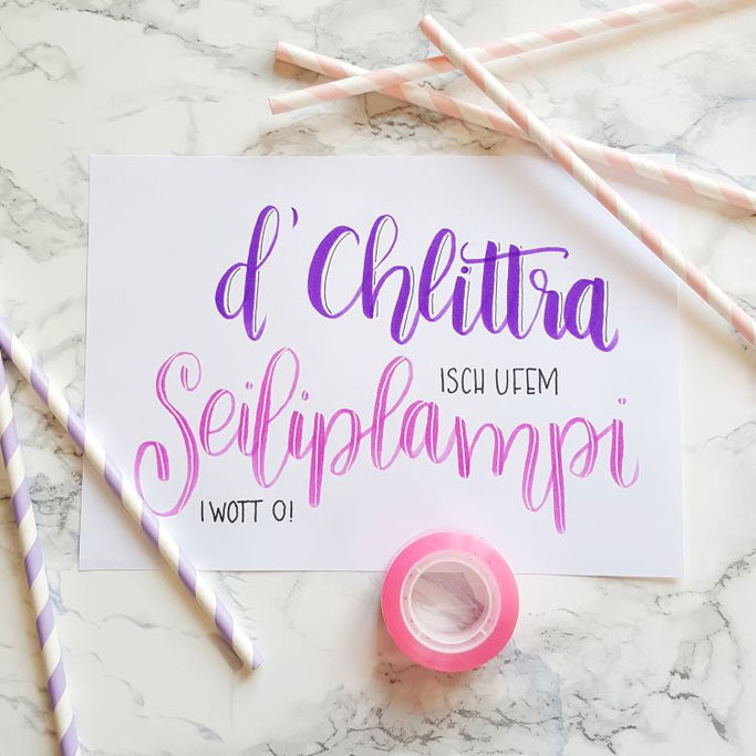 Lettering auf Schweizerdeutsch: D'Chlittra isch ufem Seiliplampi