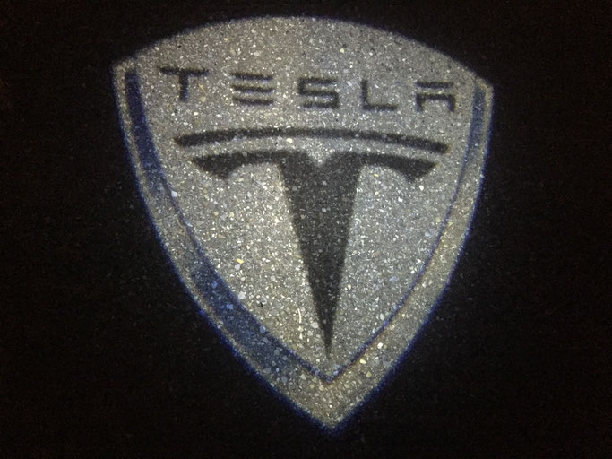 Tesla LED Logo Beamer by www.carlights.ch leuchtet aud dem Boden beim Oeffnen der Autotüre. Für Tesla Model S, bitte per email anfragen: info@carlights.ch