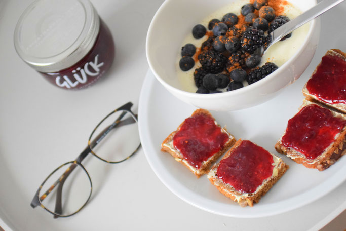 Gemütliches Frühstück im Bett mit Joghurt, Obst, Smoothie, Saft und Marmeladenbrot von Glück Marmelade.