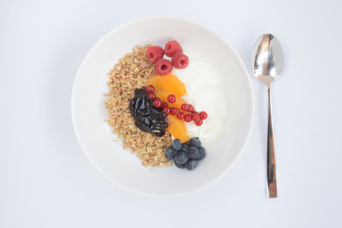 Ein leckeres, selbstgemachtes Müsli mit Orangen und Beeren getopt. Der perfekte Start in den Tag.