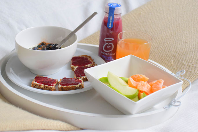 Gemütliches Frühstück im Bett mit Joghurt, Obst, Smoothie, Saft und Marmeladenbrot von Glück Marmelade.
