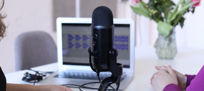 picture of two ladies with podcast microphone and laptop in background.