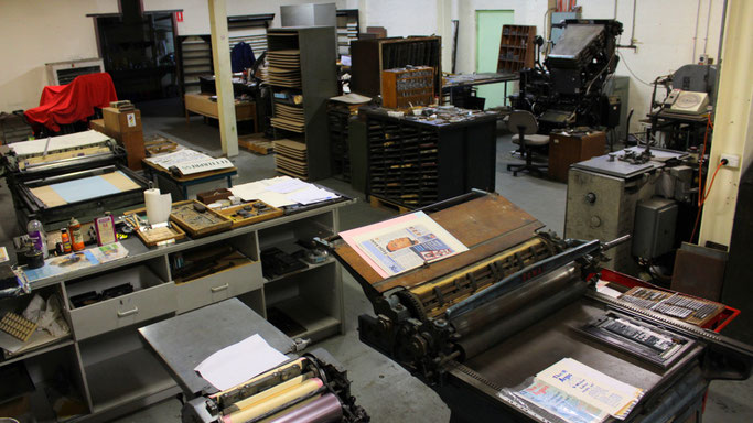 The Working Studio, including three cylinder presses; Ludlow line caster for casting solid lines of type (middle-ground right); and the Linotype Machine (rear right), for composing and casting lines of type via finger keys (see below).