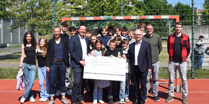 Schülerinnen und Schüler der Willi-Graf-Schulen und ihre Schulleiter Stefan Kilz und Stephan Arnold überreichen einen Scheck über 13.000 Euro an Thorsten Hoffmann und Katharina Nilles von der Diözesanstelle Weltkirche. © Ute Kirch