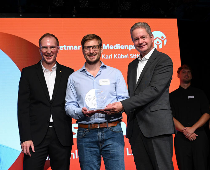 Medienpreisträger Johannes Teschner (Mitte) mit Jurymitglied Marc Wilhelm (l.) und Matthias Wilkes, Stiftungsratsvorsitzende der Karl Kübel Stiftung. © Karl Kübel Stiftung / Thomas Neu 