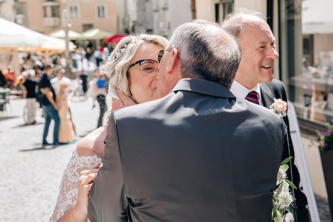 Hochzeit in Hall in Tirol Trauung Standesamt Eintreffen der Braut am Oberen Stadtplatz Bräutigam sieht Braut in weiß zum ersten Mal First Look Kuss