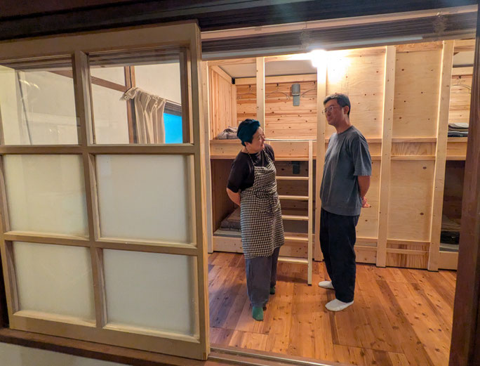 ゲストハウスのドミトリールームで話す田中さんご夫婦