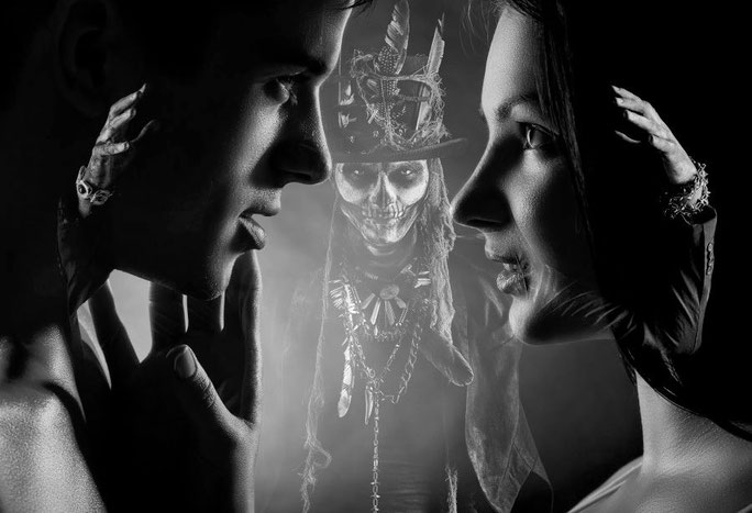 voodoo ritual verliebtes paar mit baron samedi im hintergrund