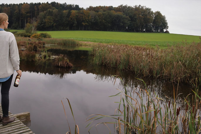 Ich stehe am See mit einer Bierflasche in der Hand