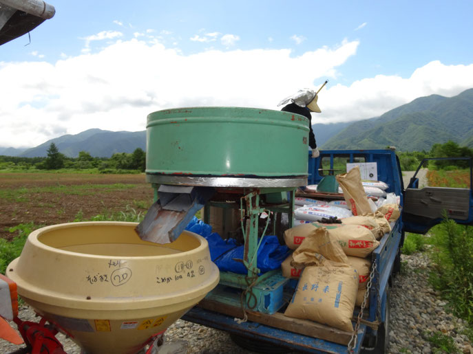 肥料と種をトラックの荷台で混ぜる