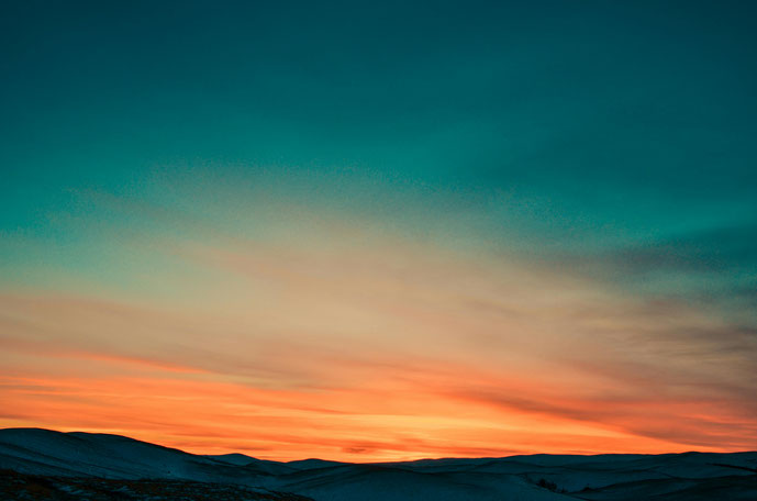 Sonnenuntergang über dunklem Gebirge