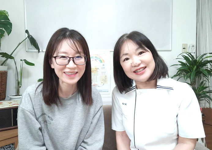 笑顔で並ぶ女性患者と院長との2ショット写真です。Q.どんな悩みがありましたか？ 小学生の頃から頭痛があり、出産後からは毎日の頭痛でもがいていました。 Q.今まで何をしてきましたか？ 病院で薬を処方してもらい鎮痛剤も併用して飲み続けていました。検査しても異常はありませんでした。 Q.施術を受けてどうなりましたか？ 施術1回目で効果を実感。薬を飲まない日が増え薬の量が激減。頭痛の原因がわかり仕事ができる生活が送れて嬉しいです。（春日井市 K.Mさん）