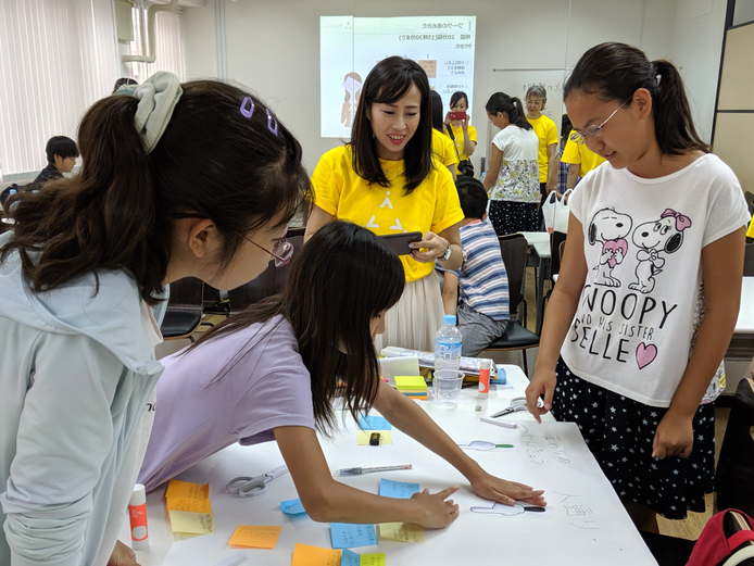 模造紙を囲んで意見を述べ合う小学生たち＝２０１９年のデータサイエンス体験講座（Rejoui提供）