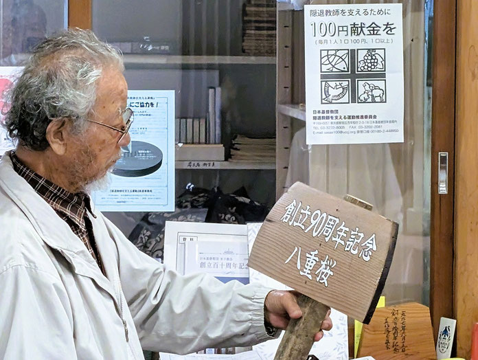 2026年6月7日（日）上の立て看板を手にとる十文字平和教会の長老、満さんです。芸術家でいらっしゃいますので、何かしみじみ思われることがあったようです。