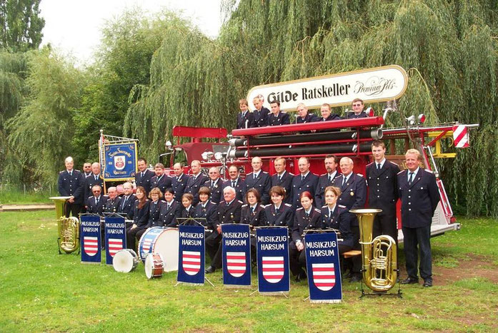 Musikzug im Jahr 2001: Gruppenfoto mit historischem Feuerwehrfahrzeug