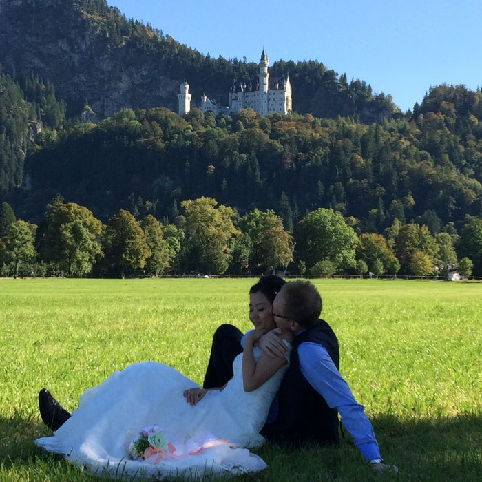 Hochzeitsfoto auf der Wiese vor Schloss Neuschwanstein