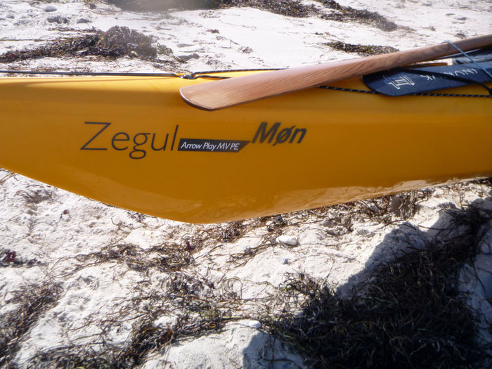 Wooden and carbon-made Greenland paddle on the deck of the kayak