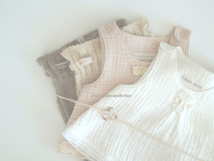 Zwei handgestrickte Hosen (Braunton und Farbe Mandel), kombiniert mit zwei passenden genähten Tuniken und einem passenden Blütenstirnband mit Perle für die Neugeborenenfotografie