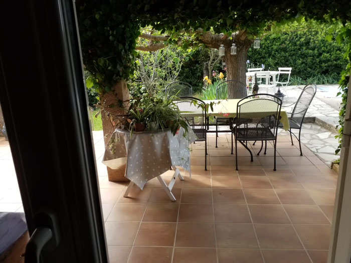 Blick auf Terrasse mit Tisch und Gartenstühlen