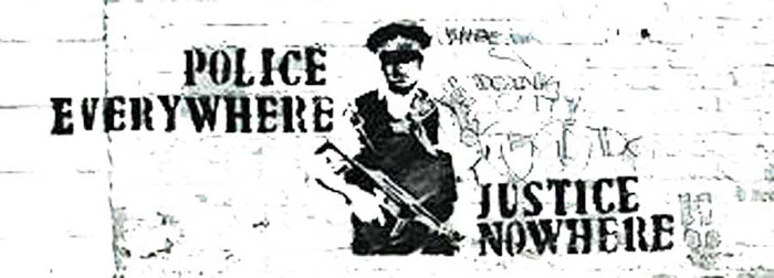 Photo of British culture: street graffiti saying 'Police everywhere, justice nowhere'.