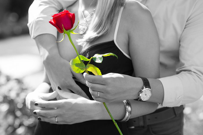 Pareja enamorada enamorada y el hombre ofrece una flor