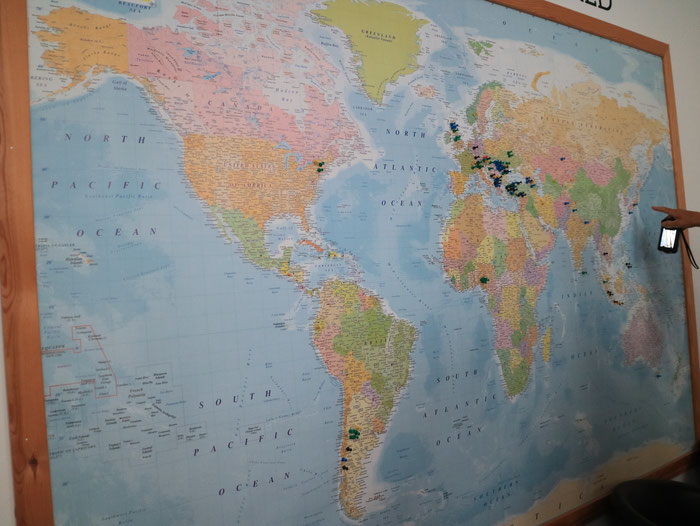 事務所に飾られた世界地図と設置場所のマップ、日本もあることに注目