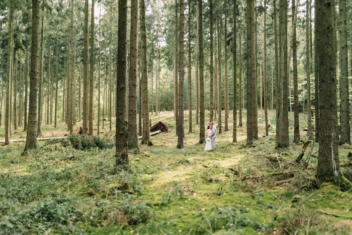 Das Paar in grüner Waldlandschaft, umgeben von Bäumen