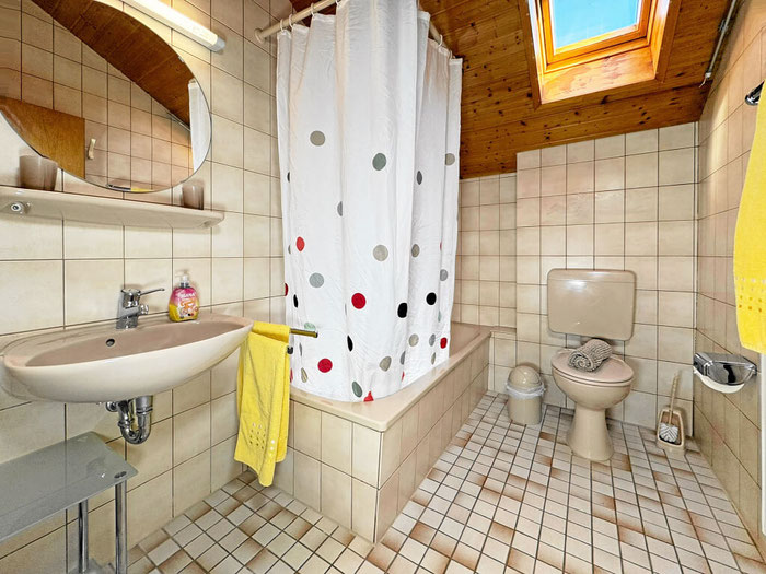 Badezimmer mit Dusch-Badewanne, WC und Waschbecken