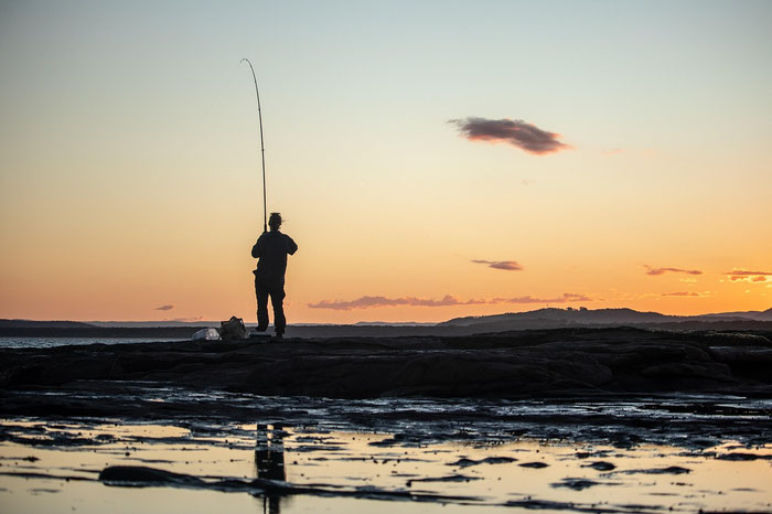 Angeln im Bretagne-Urlaub, hier: Angler im Sonnenuntergang