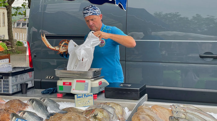Romuald Mercerand auf dem Markt in Pont-Croix beim Wiegen einer Seespinne