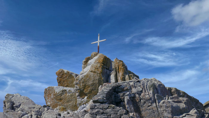 Kreuz vor dem Leuchtturm von Tévénnec, mitten im Atlantik, Bretagne