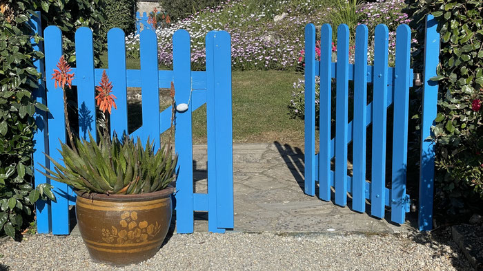 Ein blaues Törchen, der Eingang in den komplett geschlossenen Garten von Ferienhaus Ker Armor in Plouhinec.