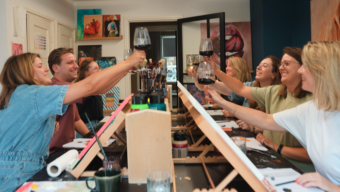 Vriendengroep heft het glas tijdens het verjaardagscadeau Sip&Paint in Breda.