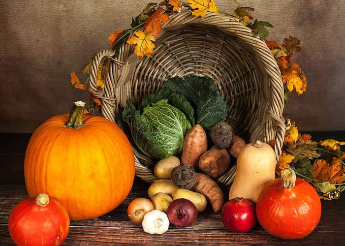 Frutta e verdura del mese di Ottobre dentro il cesto e sopra il tavolo