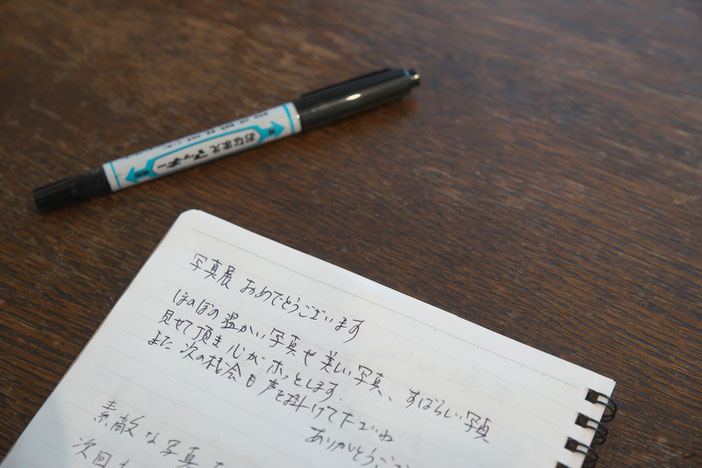 写真展の感想「写真展おめでとうございます ほのぼの温かい写真や美しい写真、、、見せて頂き心がホッとします、、、また次の機会も声を、、、」が書かれたメモ。