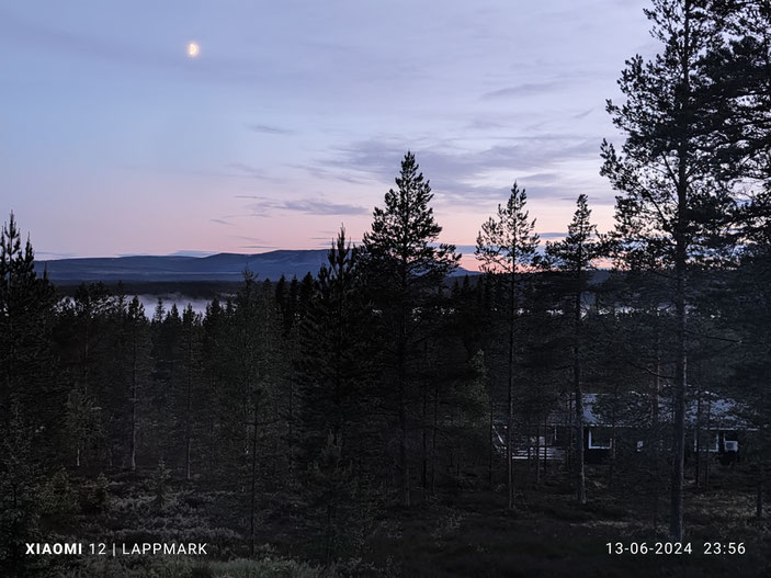 Foto vanaf Storfjäten met zicht op Fjättervalen, zacht blauwe en roze lucht en mist tussen de bomen.