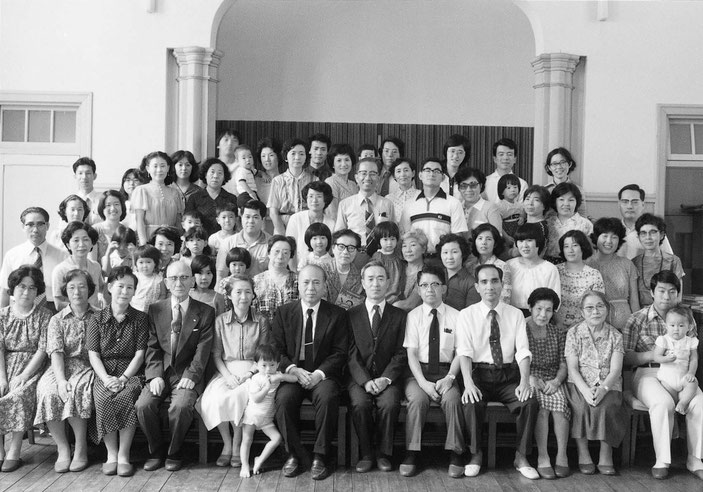 脇本寿牧師（1959年～1991年）の就任20周年感謝礼拝の記念写真。中央左寄りのこどもさんをはさんで、脇本寿牧師とお連れ合いの脇本豊子姉。