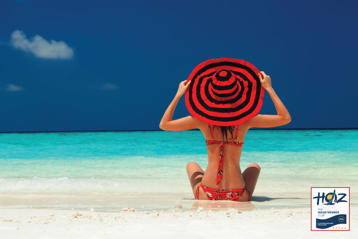 HOZ INSIDE MEMBER CLUB™ – Frau mit rotem Hut am Strand, Symbol für Freiheit und exklusive Vorteile für Mitglieder