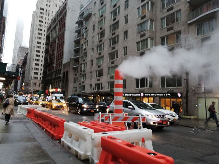 A steam pipe on a busy street in New York City