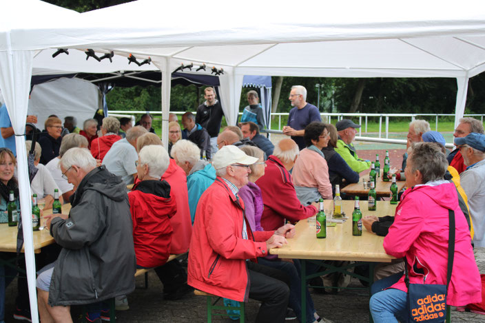 Die gute Stimmung ließen sich die feierwilligen ATSC-Mitglieder vom Regenschauer zum Start nicht nehmen. Manfred Abbes (stehend, rechts) und sein Helferteam hatten auch als Zeltbauer vorgesorgt. Fotos: R.Ströbl / put