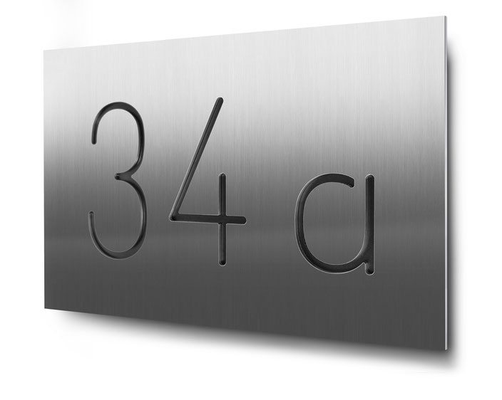 Beispiel für eine konturgeschnittene und schwarz hinterlegte dreistellige Hausnummer in Edelstahl