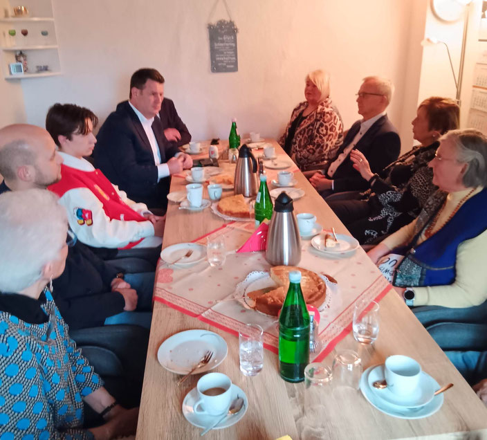 Mitglieder der Generationenhilfe sitzen mit Hubertus Heil an einer Kaffeetafel