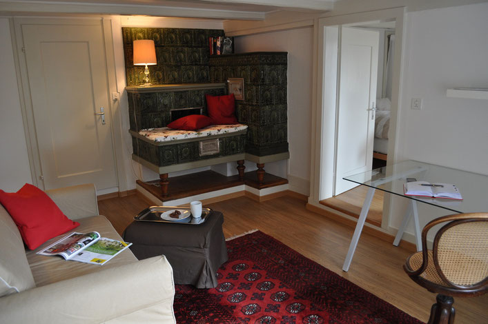 Gemütliches Wohnzimmer mit Sofabett, Schreibtisch und einer Leseecke auf der Kunst