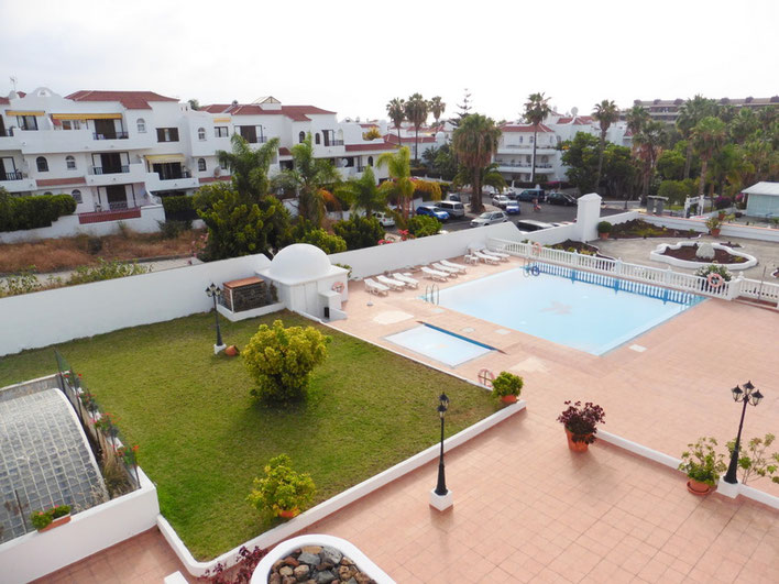 Ausblick vom Balkon zum Gemeinschaftsgarten mit Pool und im Hintergrund sieht man das Umland von La Paz.