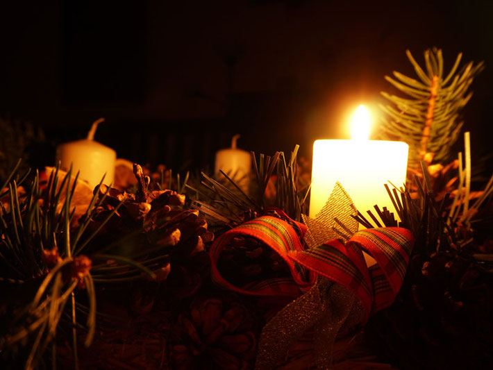 Adventskranz mit einer brennenden Kerze